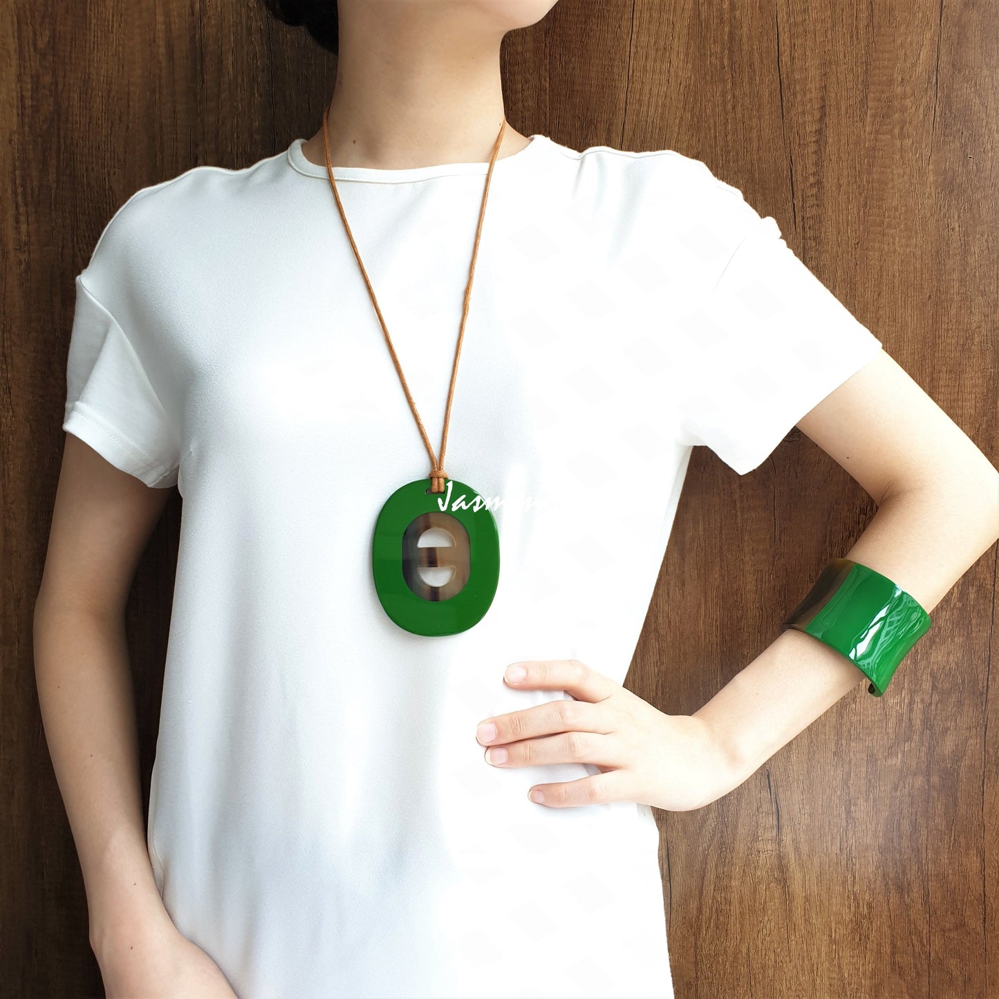 A model is wearing Jasmino unique handmade alphabet letter D pendant features green in natural buffalo horn