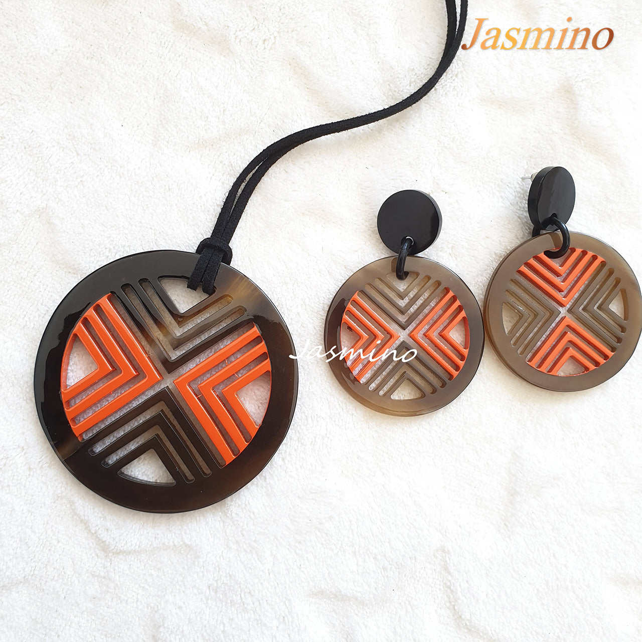 A set of unique circle orange peel  lacquer buffalo horn jewelry on the light background, impressive gift for your friend