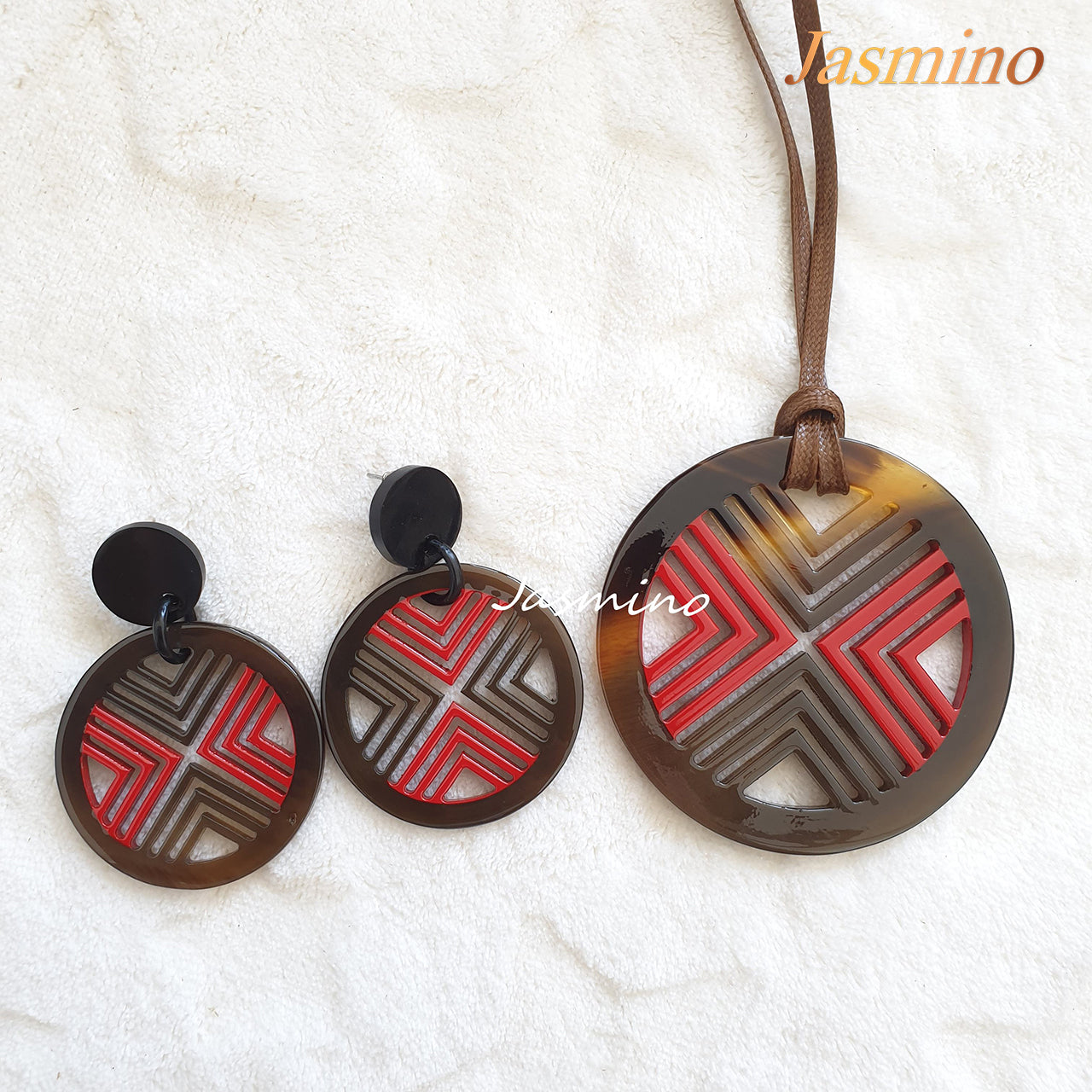 A set of unique circle red lacquer buffalo horn jewelry on the light background, impressive Christmas gift for your friend