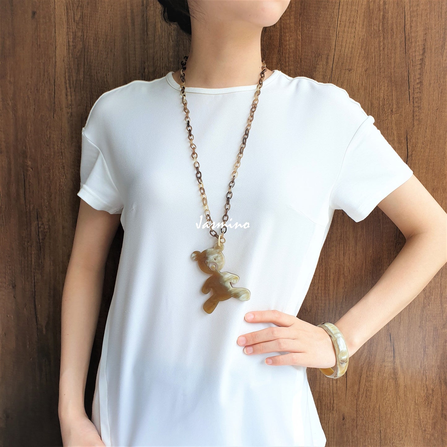 A women is wearing unique handmade pendant is shaped by a bear that is made of natural buffalo horn for girls