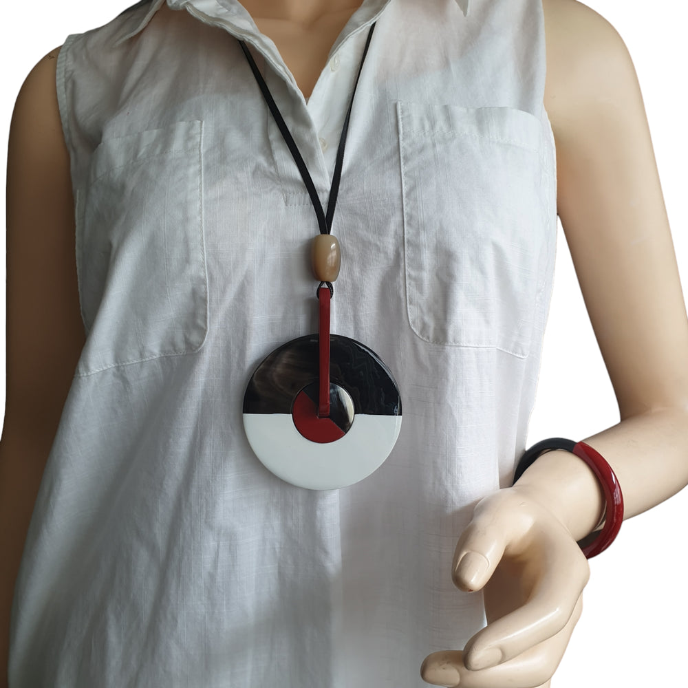 
                  
                    a model is wearing a unique pendant and a bracelet
                  
                