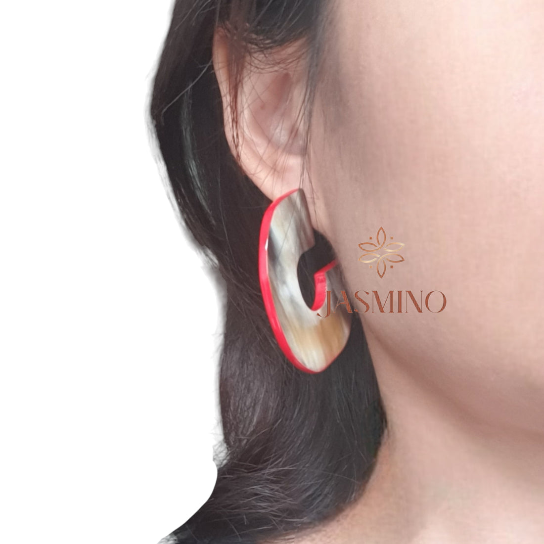 a model wearing handmade C shaped stud earrings feature scarlet red in natural buffalo horn for Spring 2024