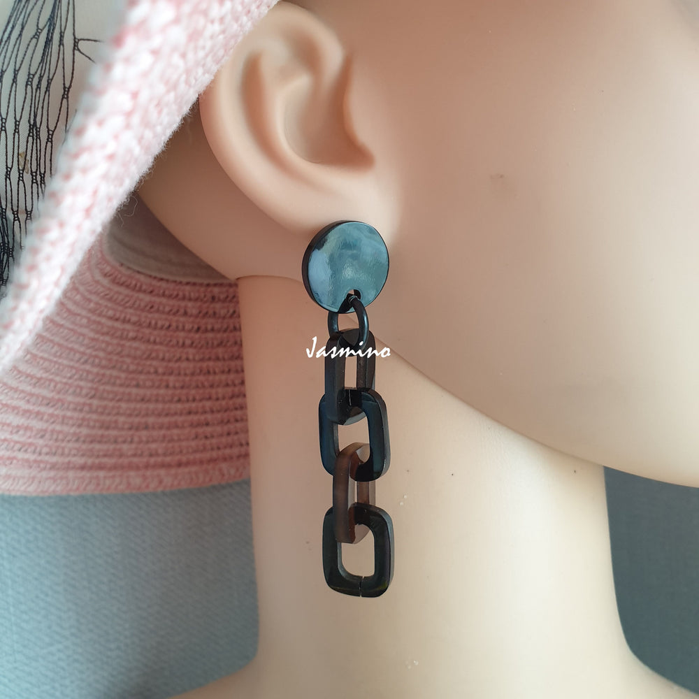 
                  
                    Handmade chain links earrings feature dark colours and natural buffalo horn material on a mannequin
                  
                