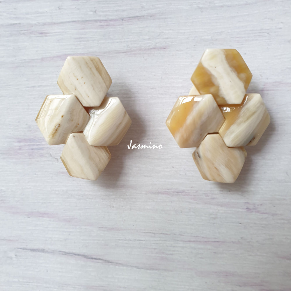 
                  
                    Handmade Geometric Earrings feature milk white color and natural buffalo horn with a bee hive shape in the natural light
                  
                
