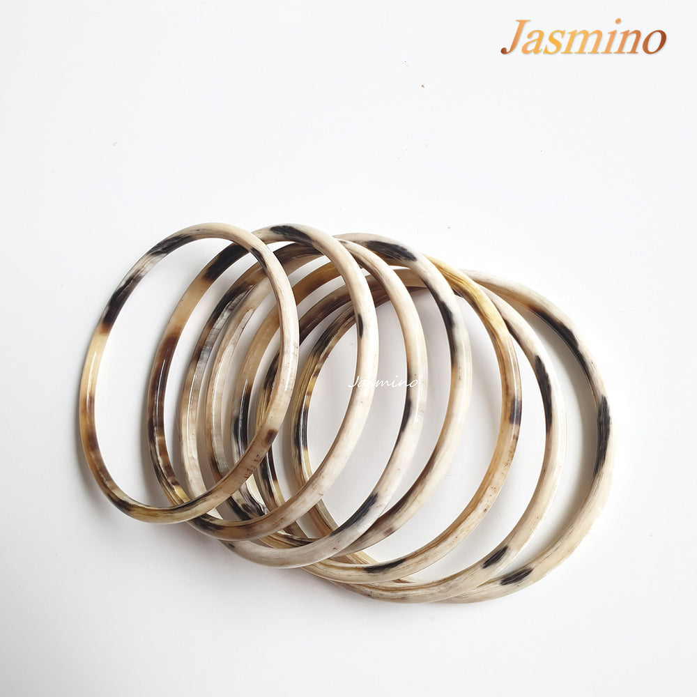 
                  
                    set of seven circle bright buffalo horn bracelets on a white background, an impressive gift for her
                  
                