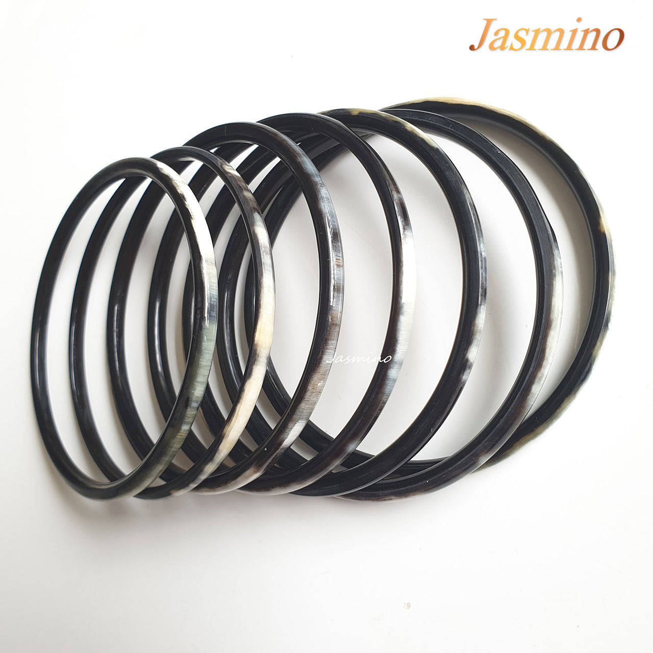 set of seven circle dark buffalo horn bracelets on a light background, an impressive gift for her