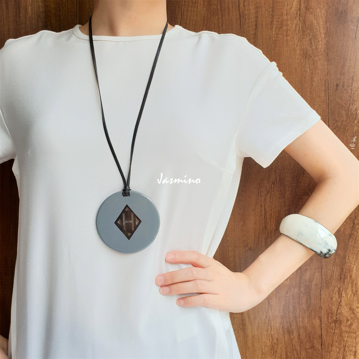 circular pendant with grey outside, inside with lozenge pattern made from natural buffalo horn on a light background, an impressive gift for her