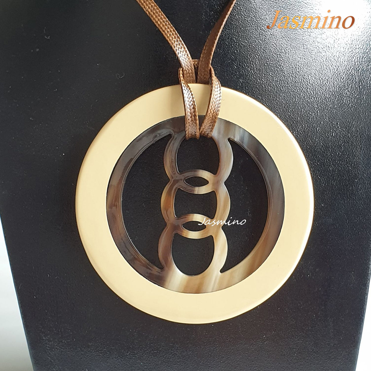 circular pendant with beige outline, inside with unique pattern made from natural buffalo horn on the light background, impressive gift for her