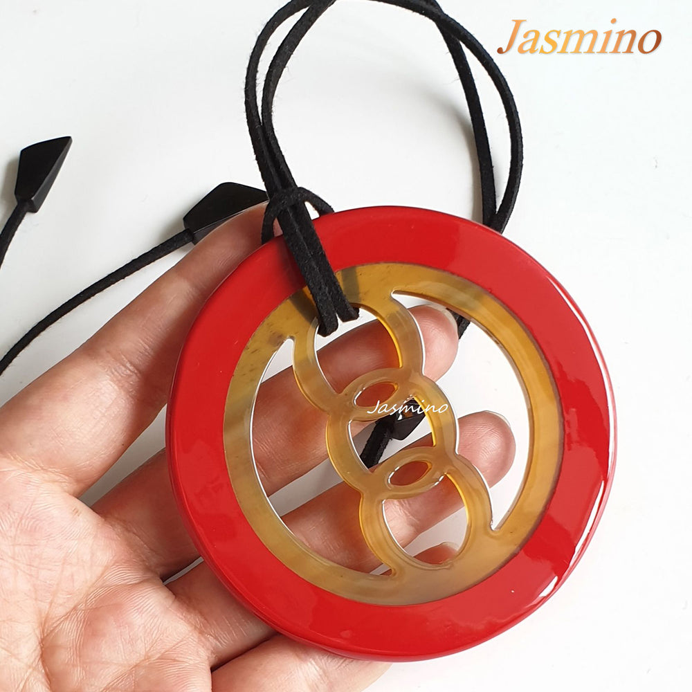 
                  
                    circular pendant with red outline, inside with unique pattern made from natural buffalo horn on the light background, impressive gift for her
                  
                