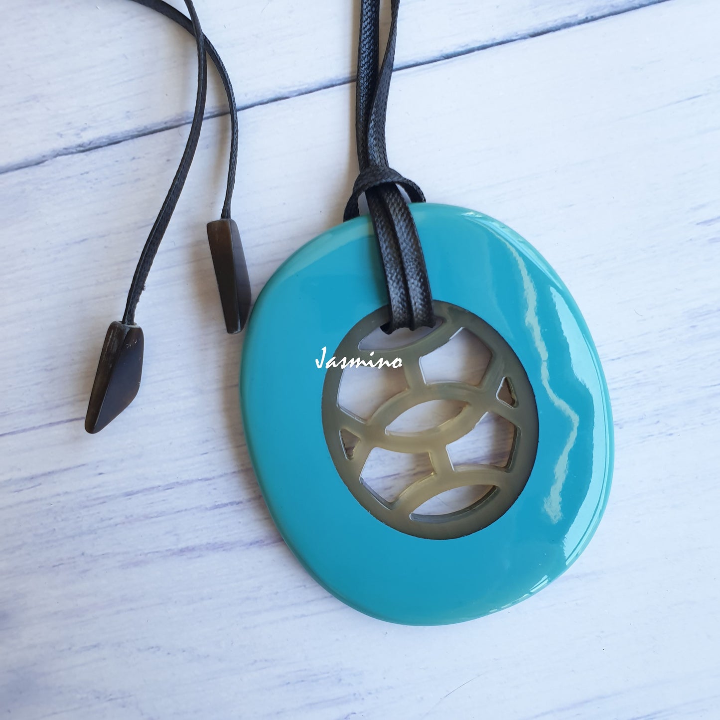 unique handmade Vintage oval pendant has a turquoise outline in natural buffalo horn for women in the natural light