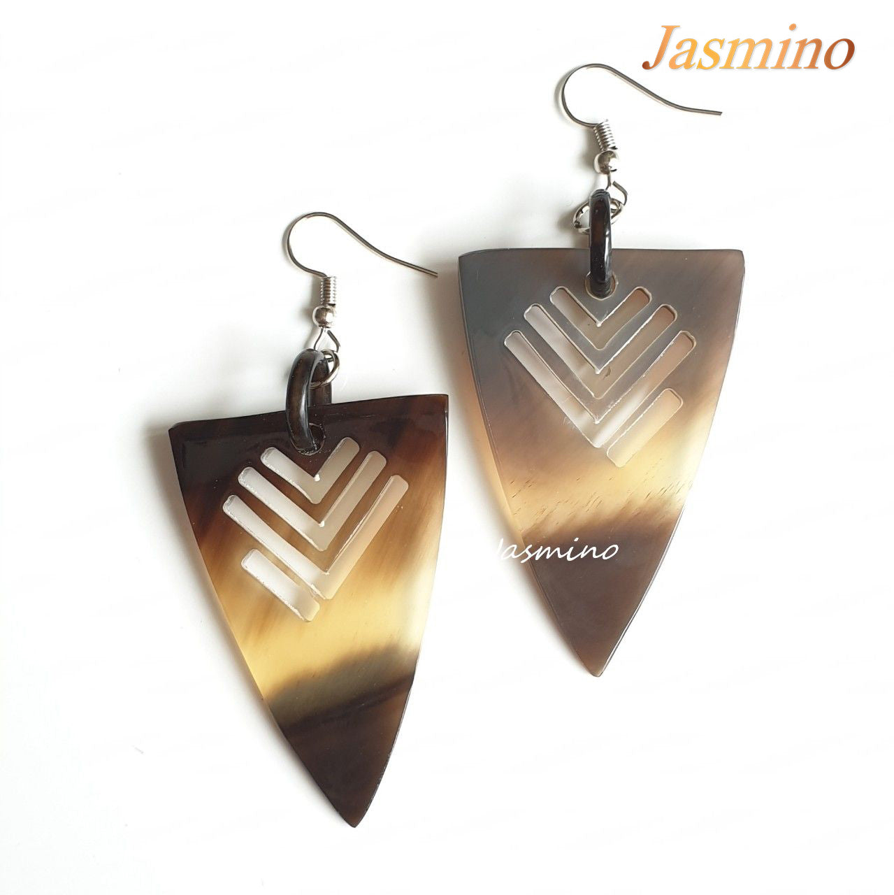 Triangle dangle earrings feature an arrow shape with amber color in the natural light 