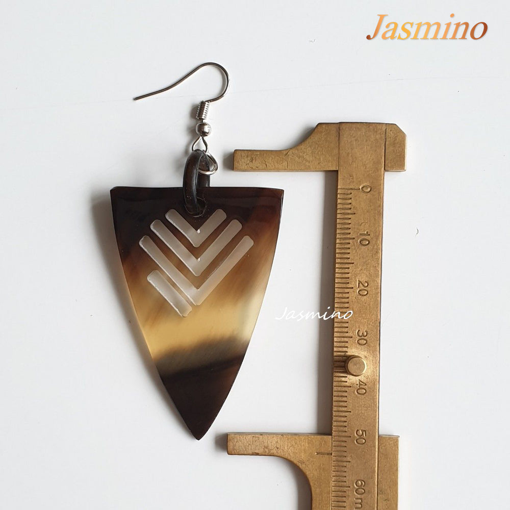 Triangle dangle earrings feature an arrow shape with amber color in the natural light 