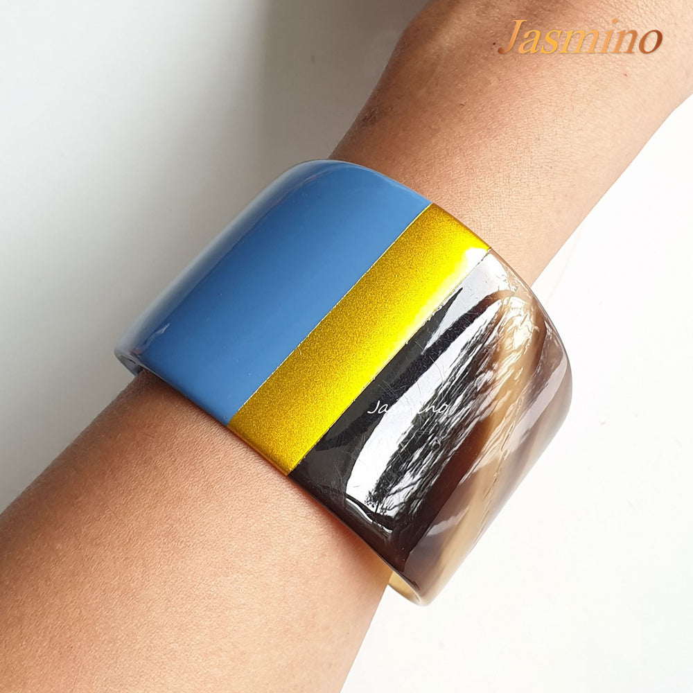 
                  
                    A model is wearing bronze- azure blue lacquer buffalo horn bracelet on the light background, impressive gift for her
                  
                