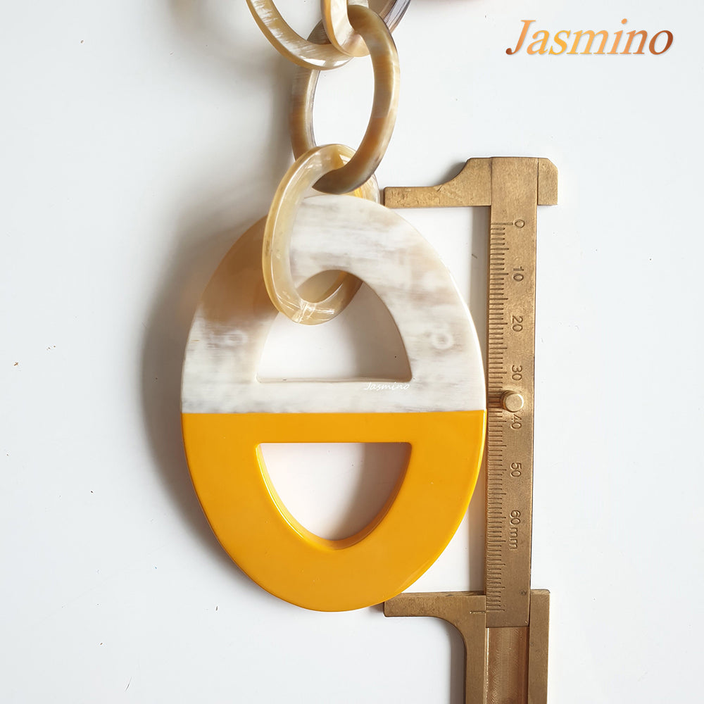 
                  
                    A yellow handmade pendant is measured by a wood ruler  on a white background
                  
                