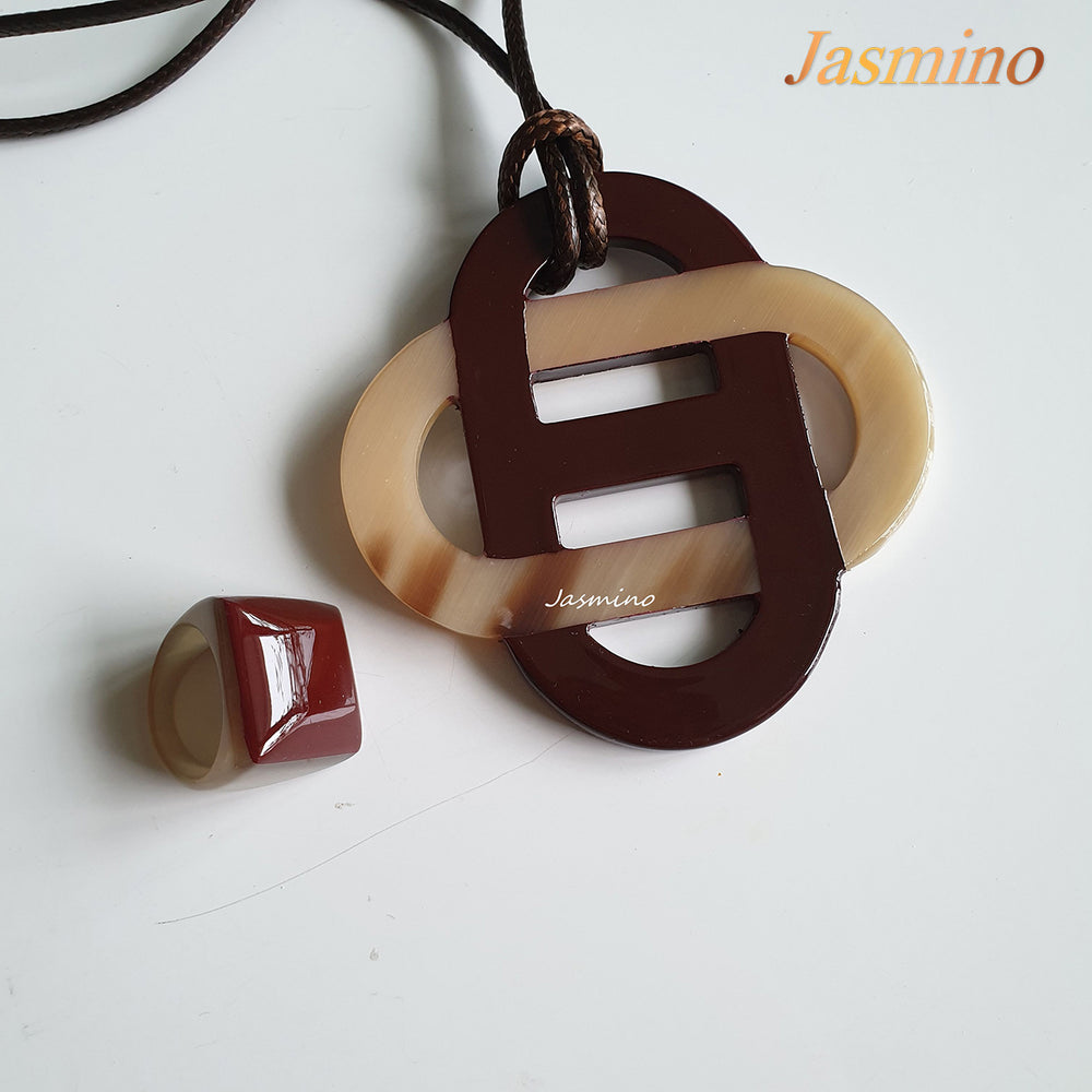 
                  
                    A set of fired brick lacquer pendant and ring on the light background, impressive gift for her
                  
                