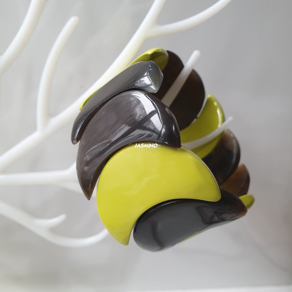 
                  
                    handmade bangle bracelet features black and lime green in natural buffalo horn for Spring 2023 on faux branches
                  
                