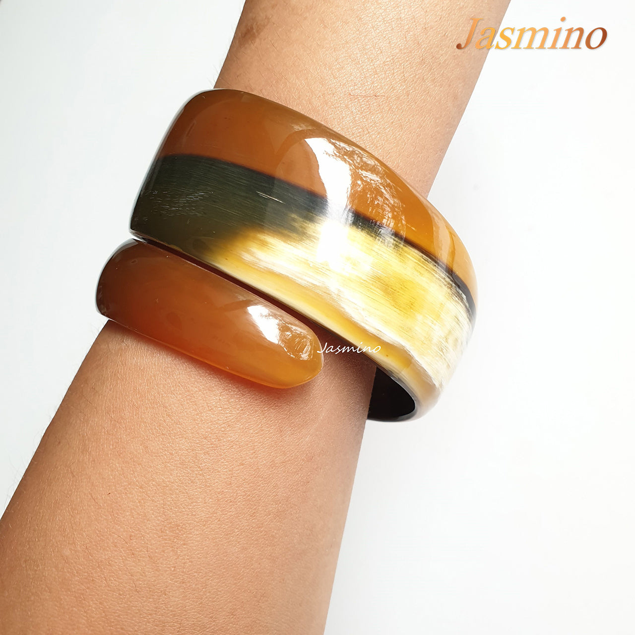 A model is wearing natural horn snake cuff bracelet on the light background, unique gift for your friend