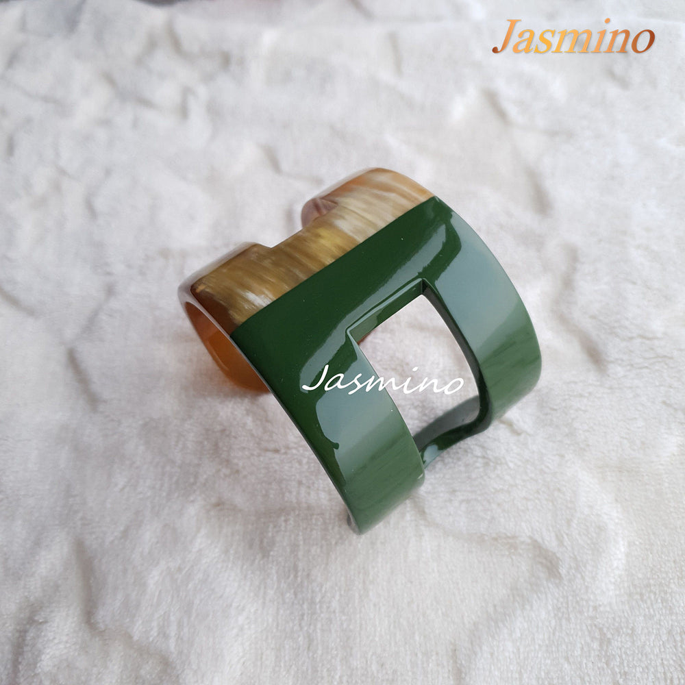 
                  
                    A cuff bracelet is designed with half natural buffalo horn and half chive lacquer in the natural light
                  
                