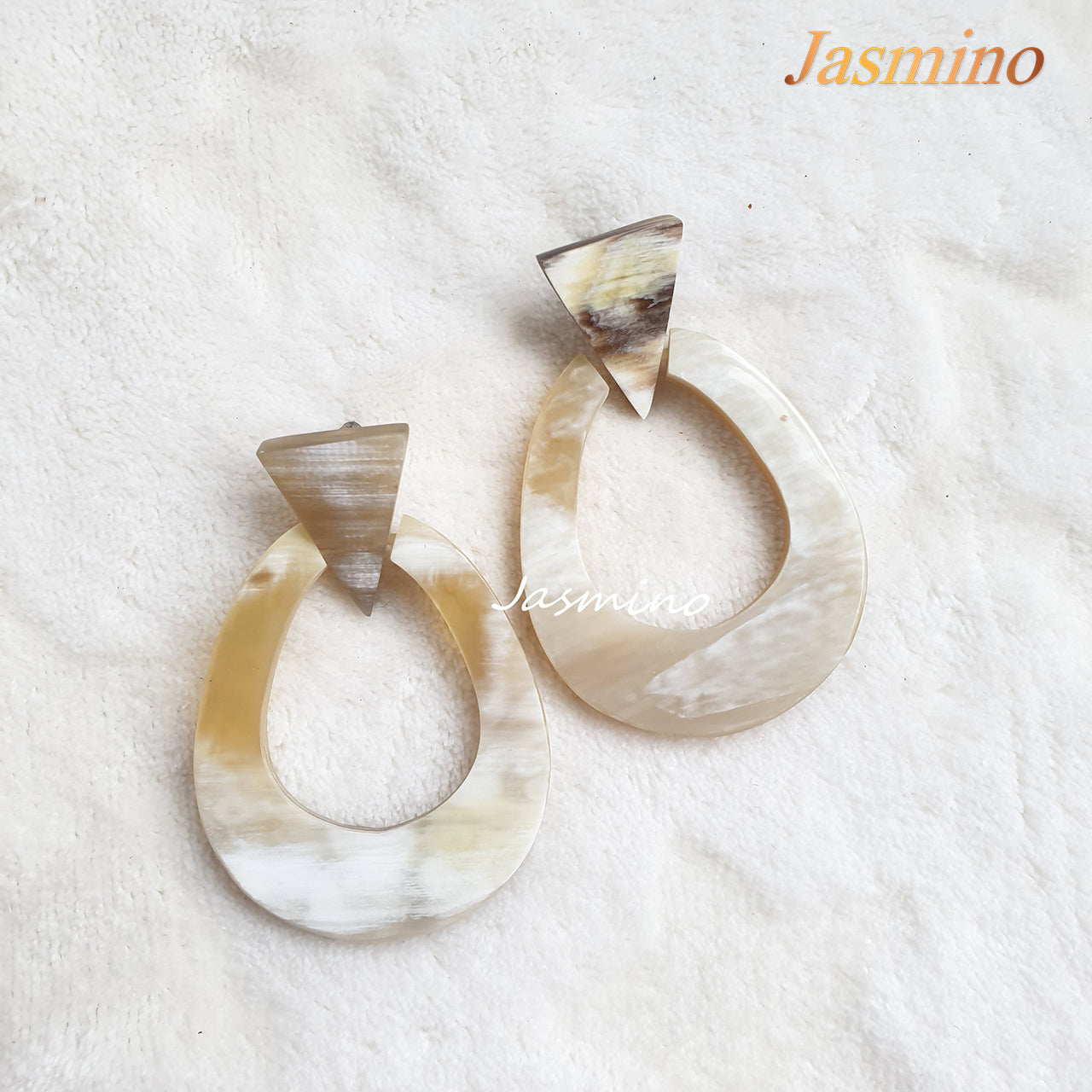 Handmade oval earrings are made of natural buffalo horn with a bright color in the natural light