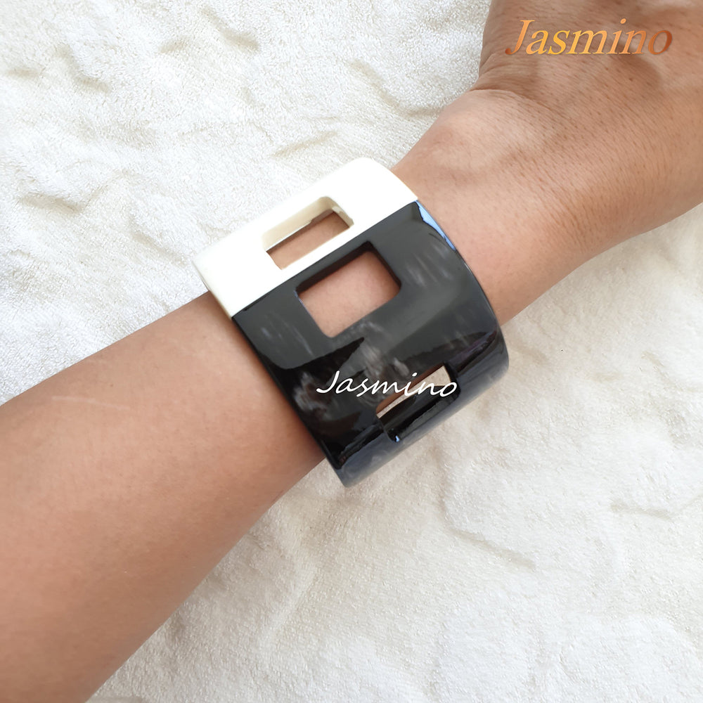
                  
                    A model is wearing the cuff bracelet designed with half black and half white lacquer, unique gift for her
                  
                