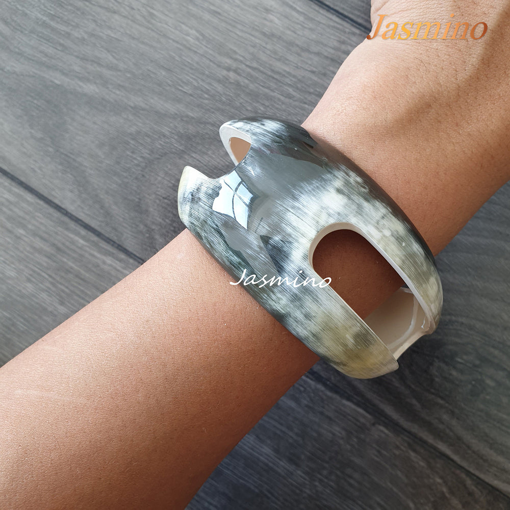 
                  
                    A model is wearing Jasmino unique handmade Vintage cuff bracelet featured bright colours in natural buffalo horn for women
                  
                