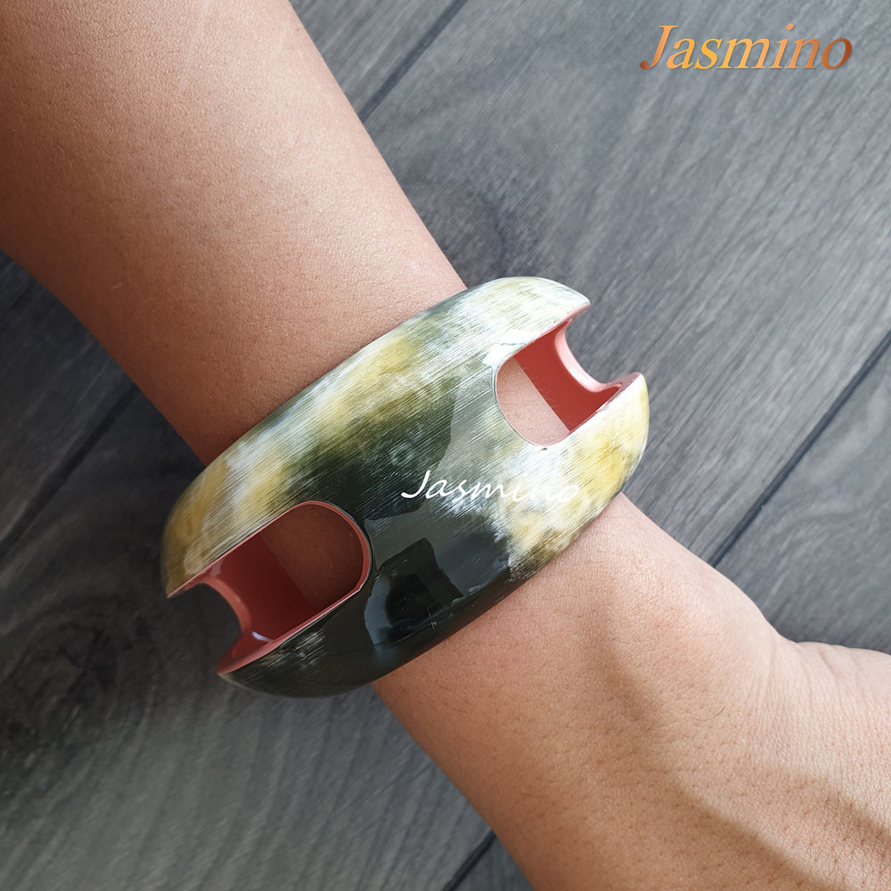 
                  
                    A model is wearing Jasmino unique handmade Vintage cuff bracelet featured bright colours in natural buffalo horn for women
                  
                