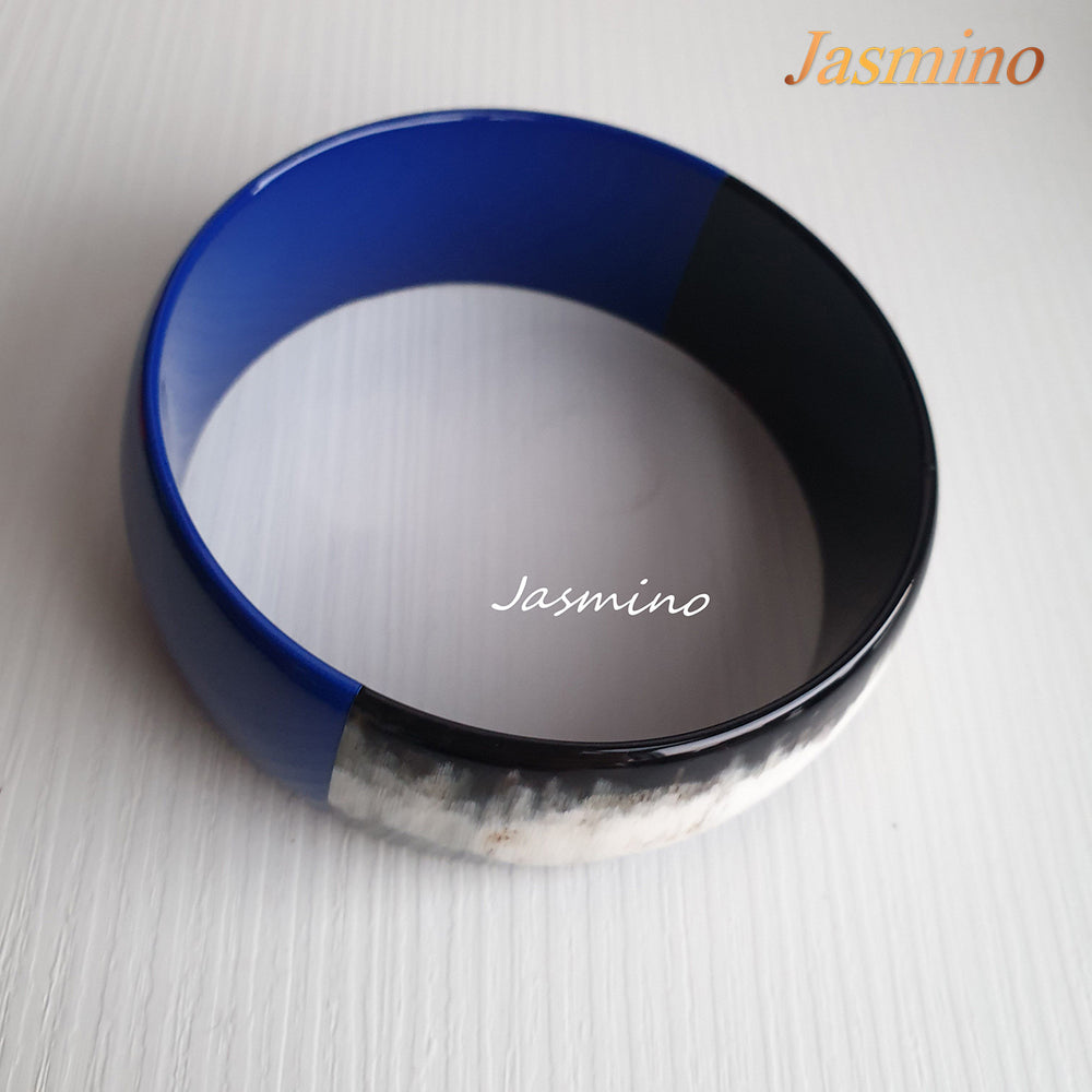 
                  
                    Buffalo horn bangle with half natural horn and half painted classic blue on the light background, impressive gift for her
                  
                