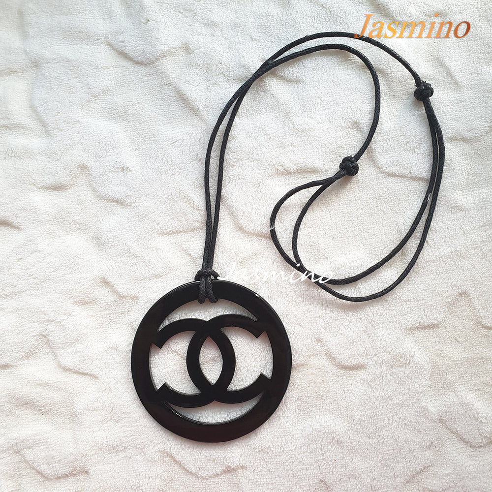 
                  
                    black pendant with Chanel symbol in natural light, unique gift for your friend
                  
                