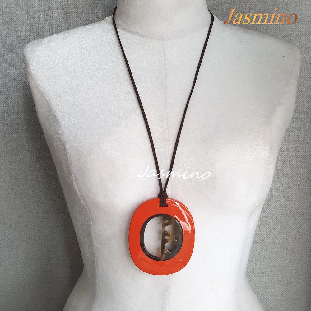 
                  
                    elliptical orange peel horn pendant on the light background, impressive gift for her
                  
                
