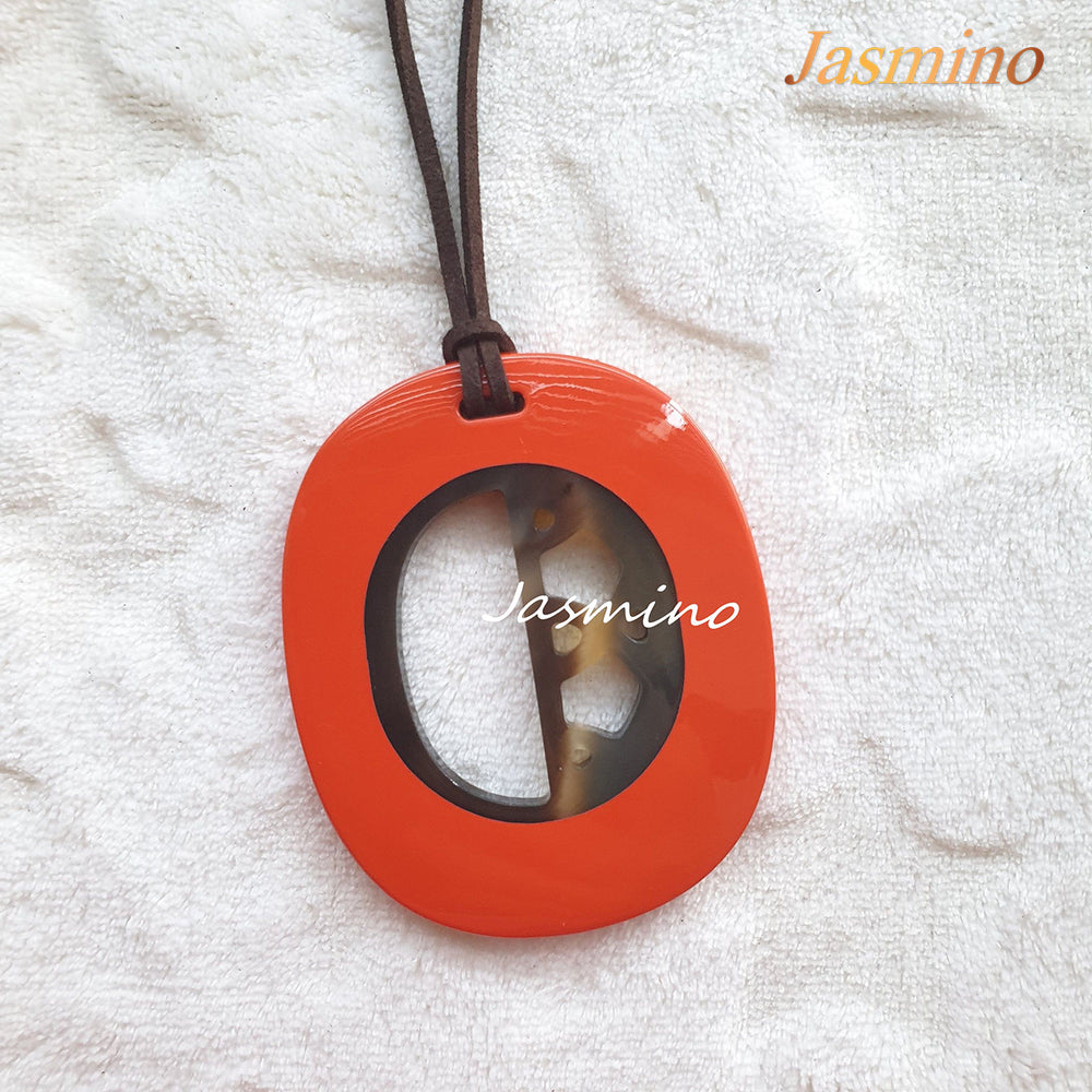
                  
                    elliptical orange peel horn pendant on the light background, impressive gift for her
                  
                