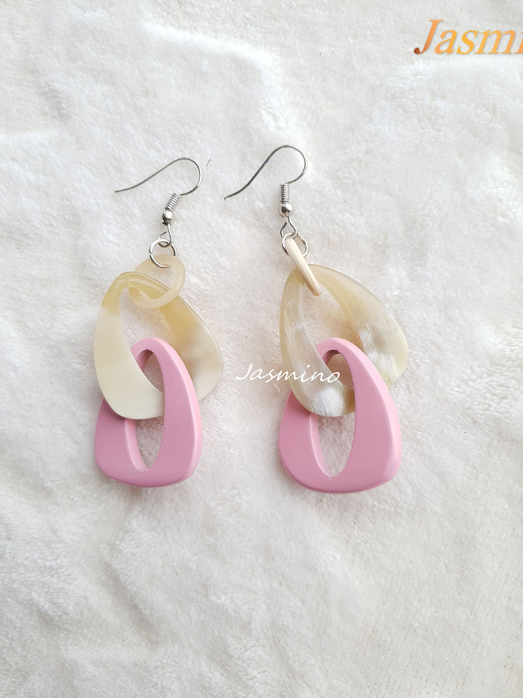 
                  
                    Handmade triangle dangle earrings are designed by pink and white color
                  
                