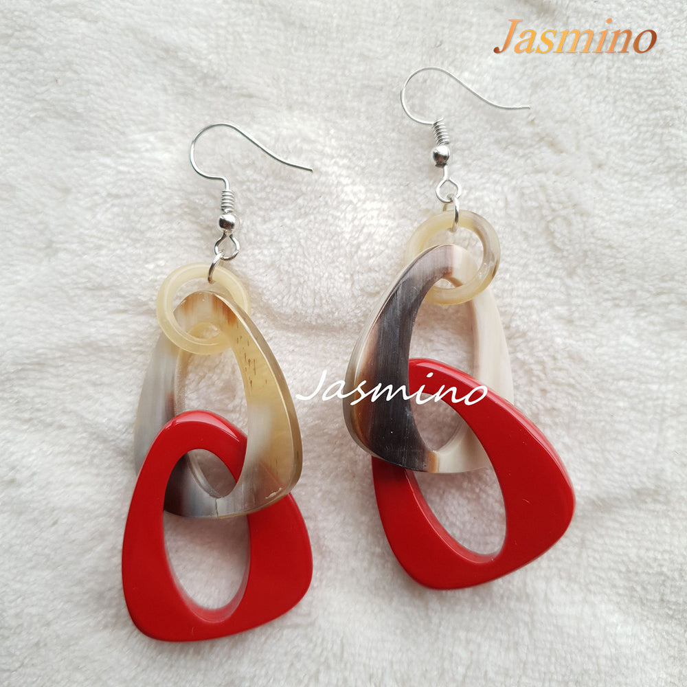 
                  
                    Handmade triangle dangle earrings are designed by red and amber color in the natural light
                  
                