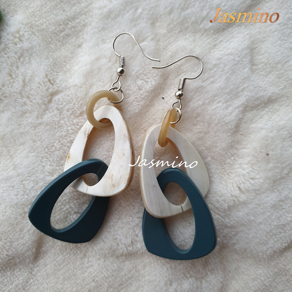 
                  
                    Handmade triangle dangle earrings are designed by cadet blue and white color in the natural light
                  
                