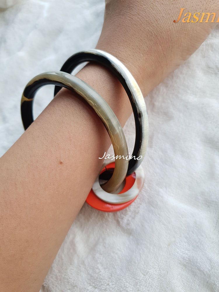 
                  
                    A model is wearing Jasmino unique handmade Bohemian Vintage double circle thin bracelet detailed by three bright small circles in natural buffalo horn for women's gifts
                  
                