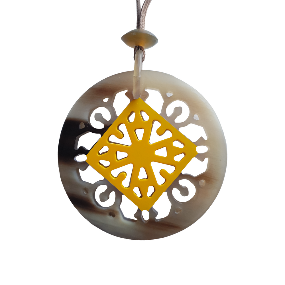 
                  
                    round pendant with dark natural buffalo horn contour, inside with unique lozenge pattern made from buffalo horn painted saffron yellow on a light background, is an impressive gift for her
                  
                
