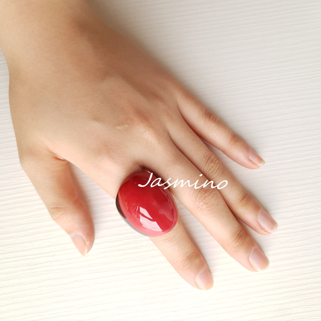 A mode is  wearing brick red large oval ring in natural buffalo horn for women's gifts