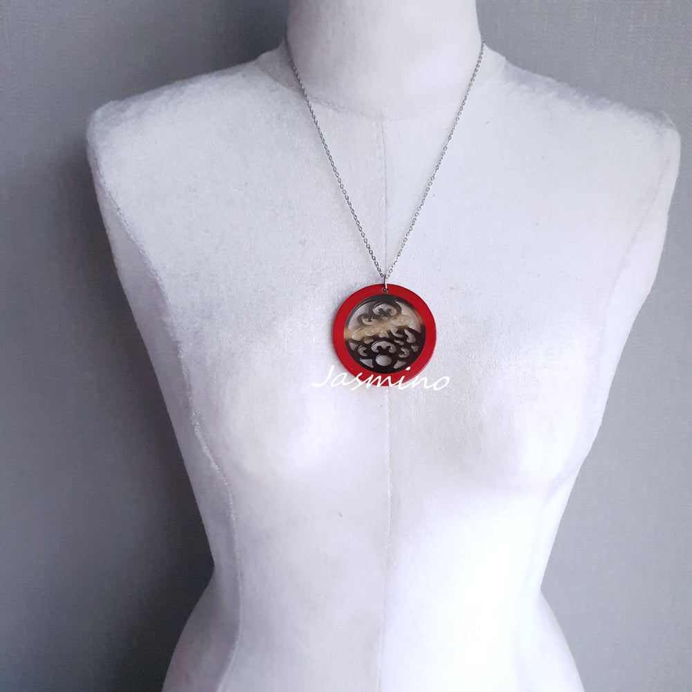
                  
                    necklace has a circle pendant with scarlet outline, inside with unique pattern made from natural buffalo horn on the light background, impressive Christmas gift for her
                  
                