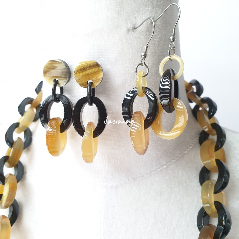 
                  
                    A set of one small chain link necklace and two handmade earrings in the natural light
                  
                