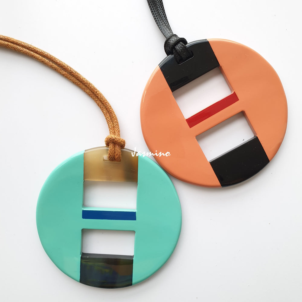 
                  
                    Two unique handmade circle pendants feature turquoise and orange in natural buffalo horn for women
                  
                