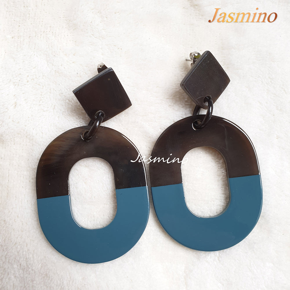 
                  
                    Handmade oval earrings feature pantone blue with natural buffalo horn material in the natural light
                  
                