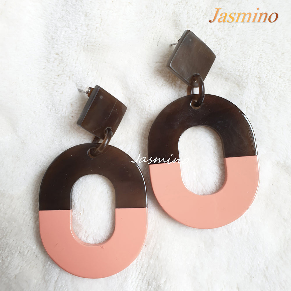 
                  
                    Handmade oval drop earrings feature coral pink and dark brown color with natural buffalo horn material in the natural light
                  
                