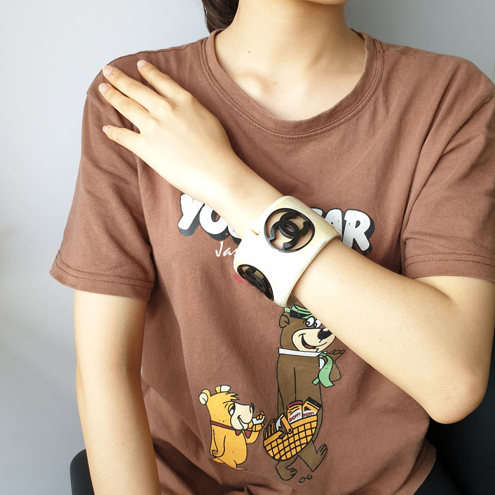 
                  
                    natural horn bracelet with black Chanel symbol on a hand, a unique gift for her
                  
                