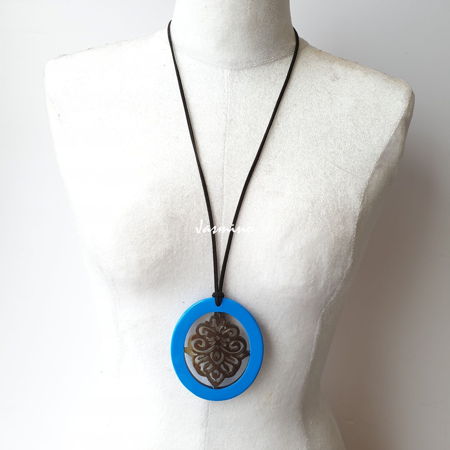 elliptical sky blue horn pendant with unique patter non the light background, impressive gift for her