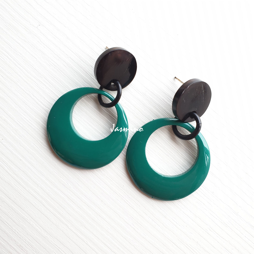 
                  
                    Jasmino elegant crescent moon earrings feature pine green in the natural light
                  
                