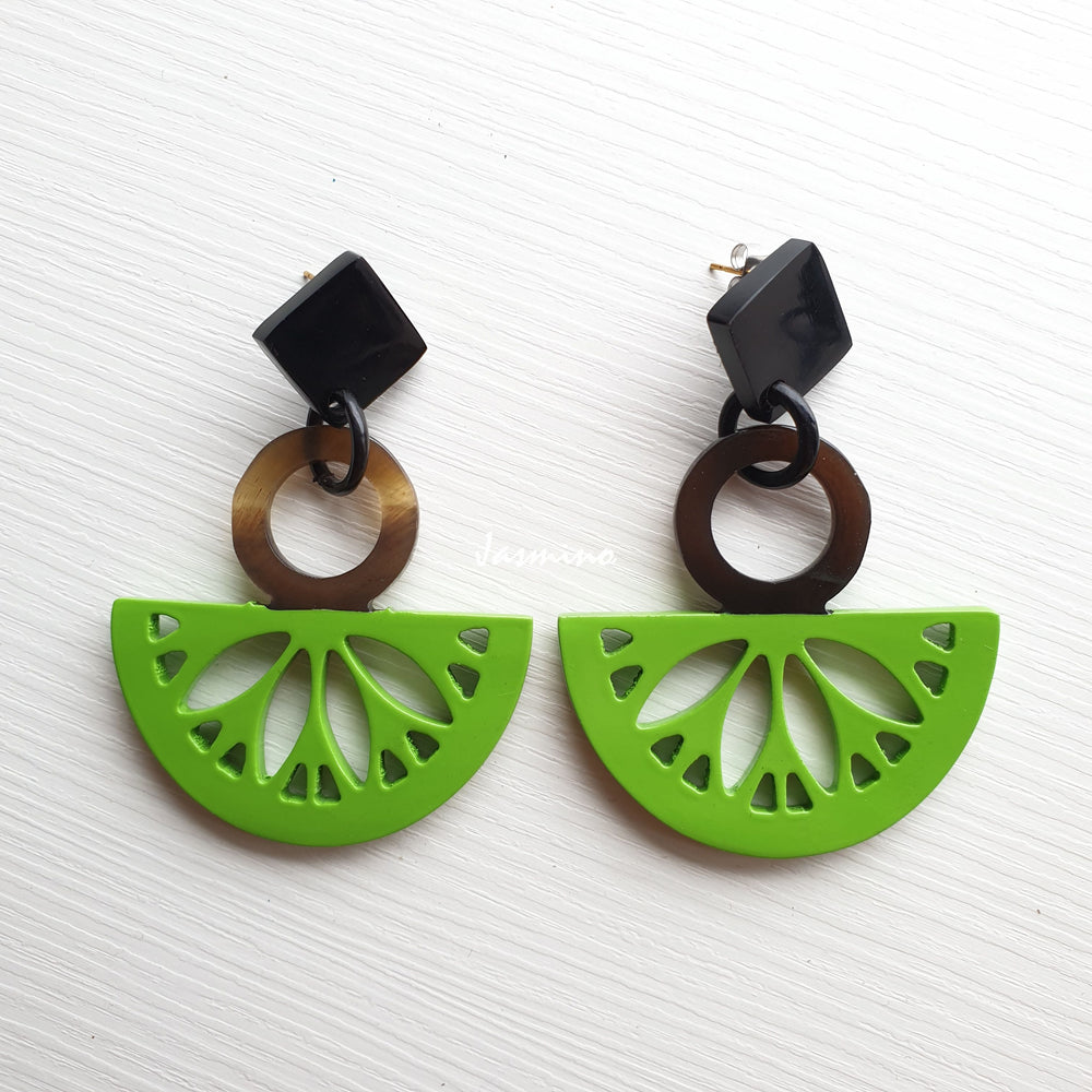 
                  
                    Handmade drop earrings are detailed by Kiwi fruit shape with bright green color and natural buffalo horn material in the natural light
                  
                