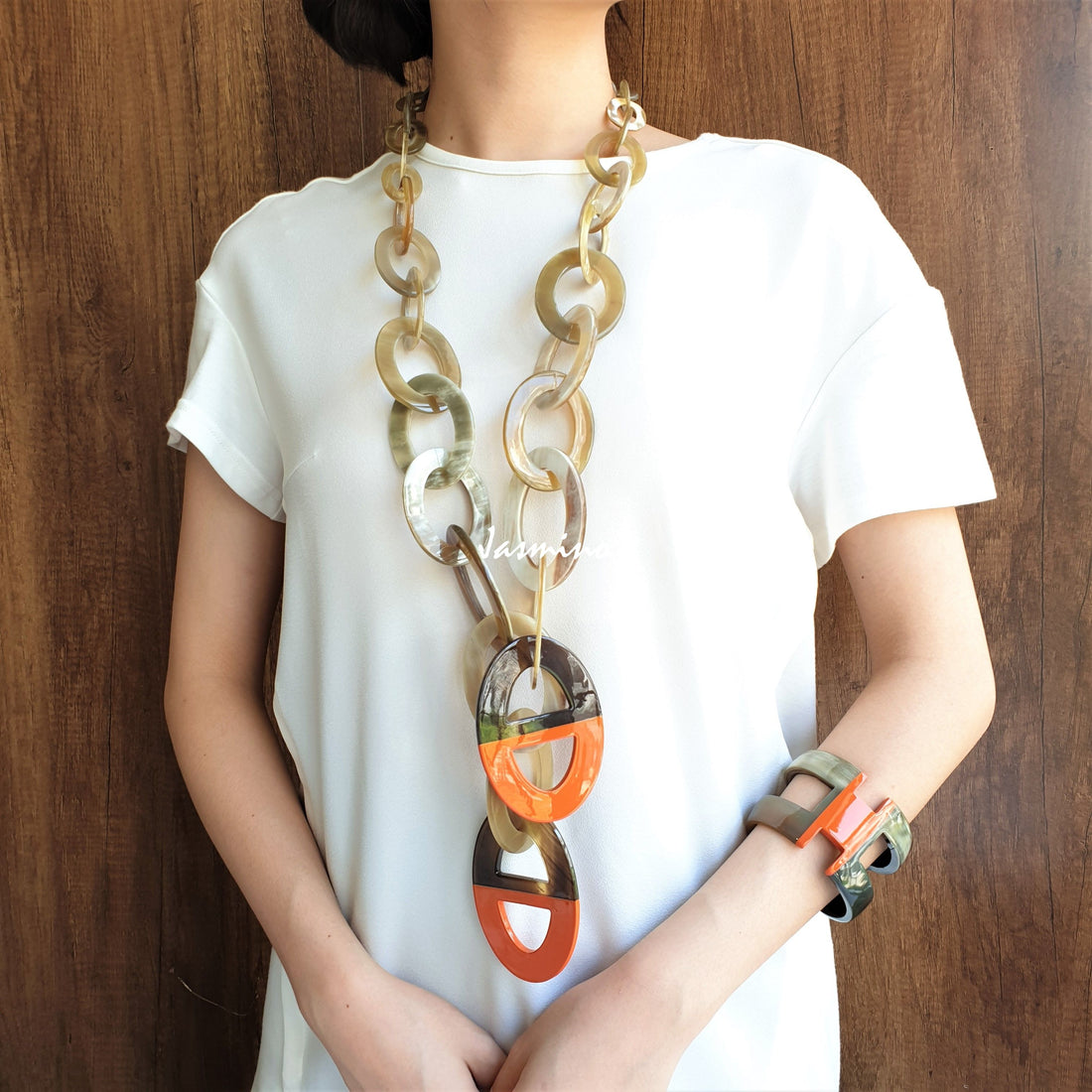 A model is wearing unique handmade Bohemian chain link necklace and H-shaped cuff bracelet featured orange and white in natural buffalo horn on Thanksgiving