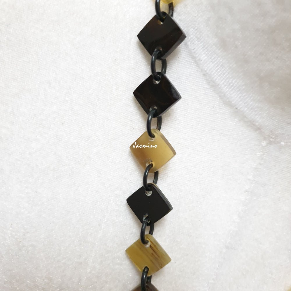 
                  
                    unique handmade Bohemian Ethnic diamond shaped chain link accessory is detailed by dark colours and bright circles in natural buffalo horn for festivals
                  
                