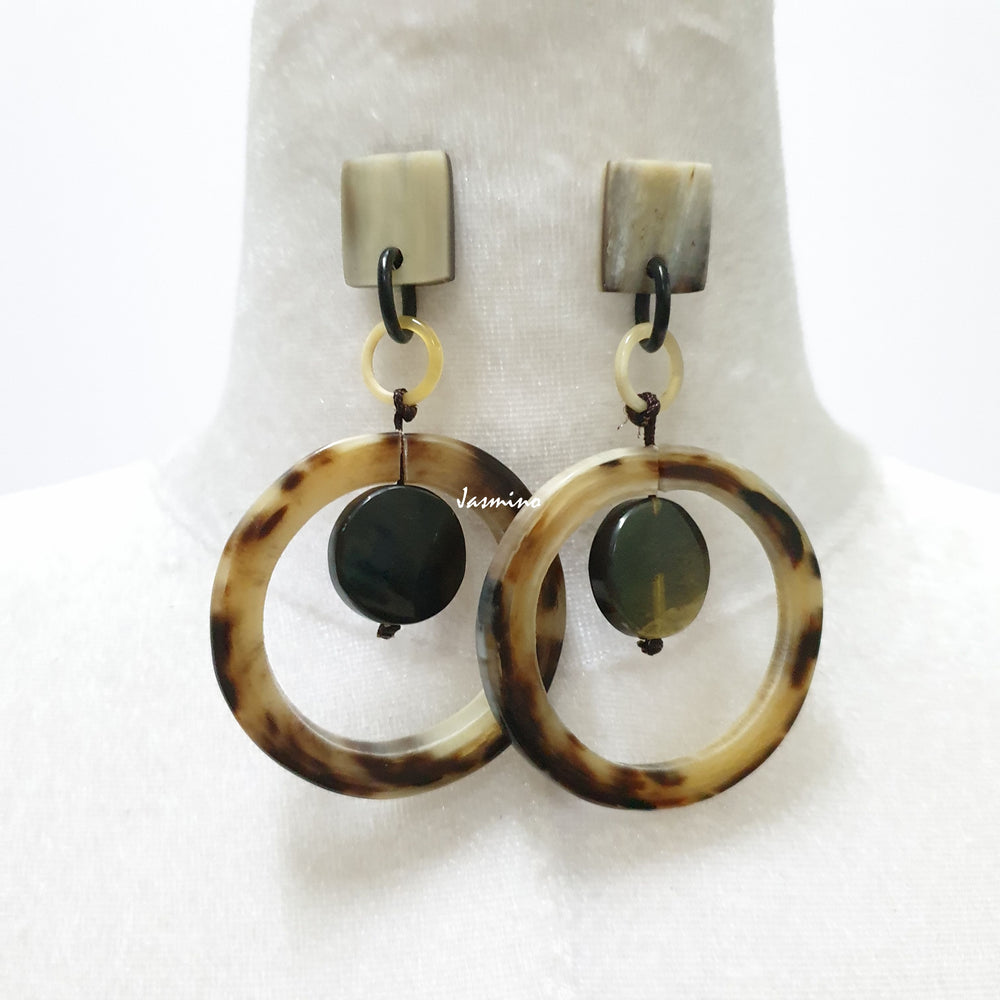 Handmade sphere earrings made of natural dark horns on a light background