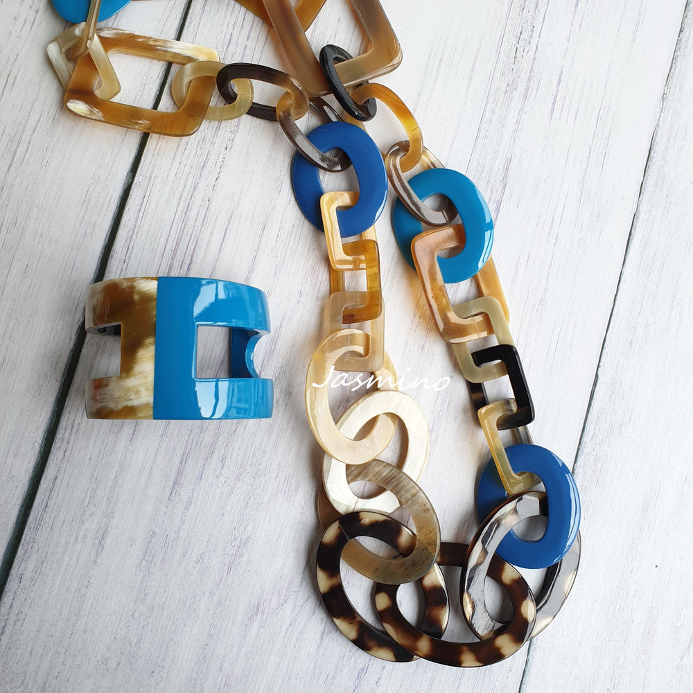 
                  
                    A set of unique handmade circle rectangle chain link and H-shaped cuff bracelet features black and blue in natural buffalo horn
                  
                
