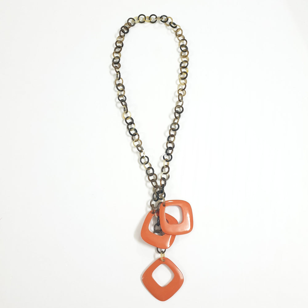 
                  
                    The necklace is designed with three large diamond-shaped pieces lacquered in orange at the bottom, an impressive gift for her
                  
                
